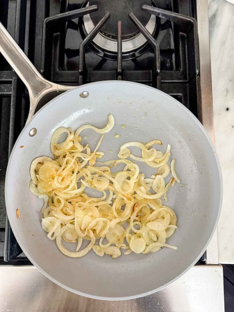 Vidalia onions in saute pan by Caraway on a gas stove.
