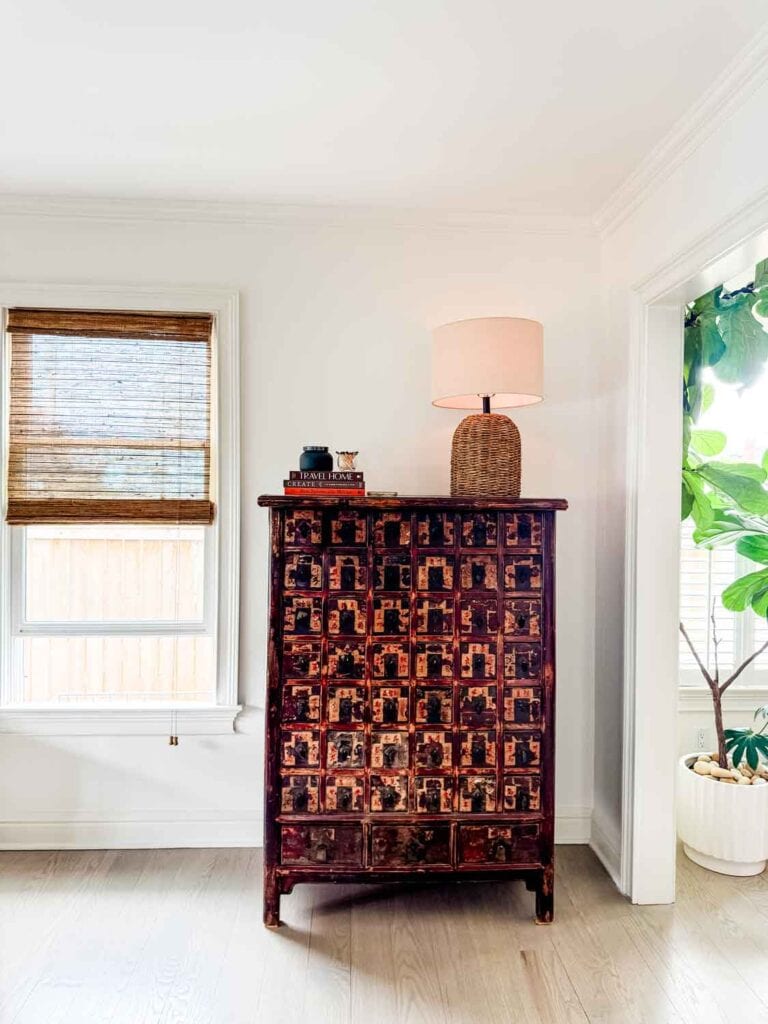 Vintage apothacary chest with wicker lamp.