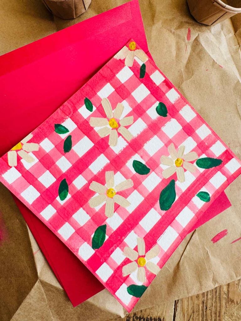 Red and white painted card, daisies on card with red envelope. 