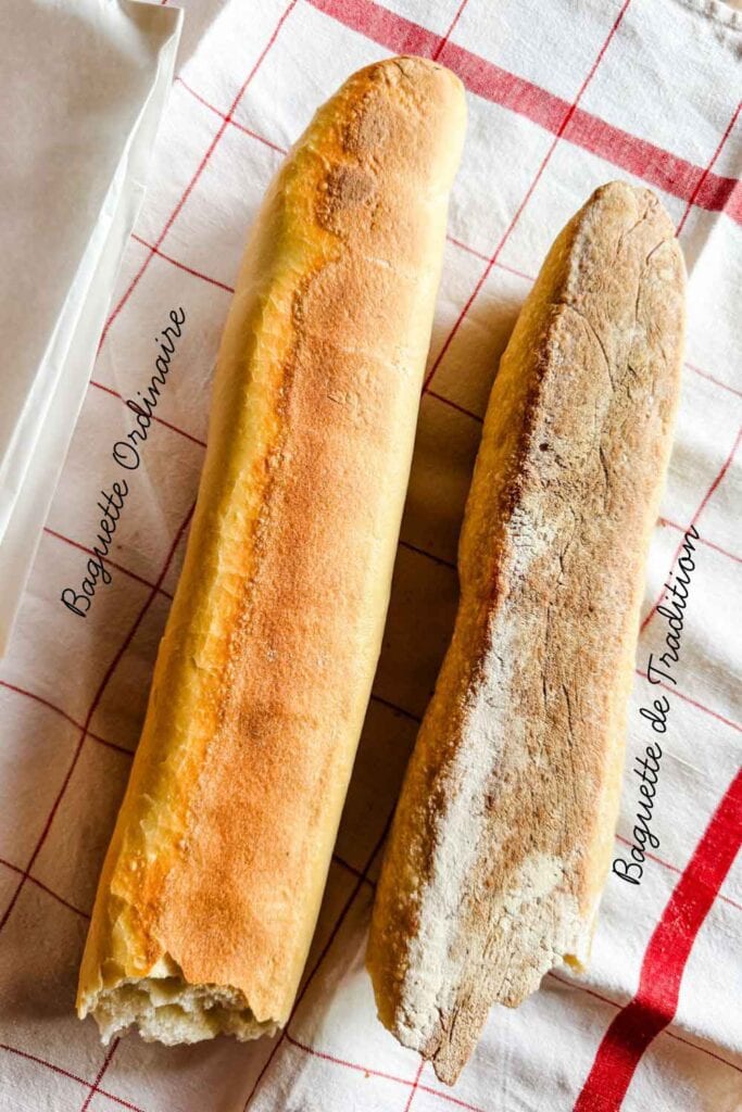 The bottoms of these two baguettes are facing up and one is labeled baguette ordinarie and one is labeled baguette de tradition.