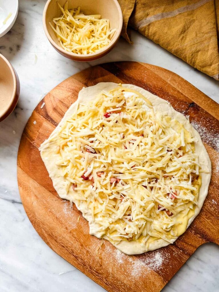 Pizza on peel with cheese.