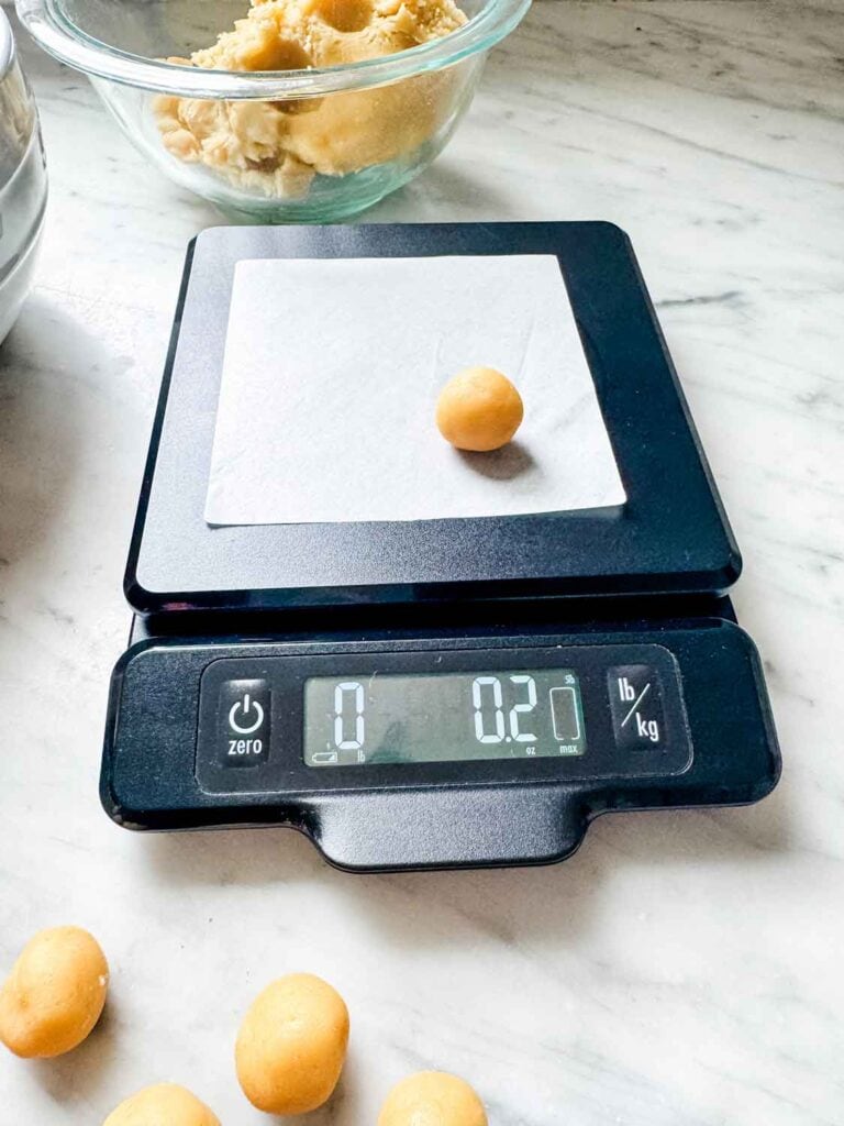 Vanilla and chocolate cookie dough, small dough balls, kitchen scale reading 0.2 ounces.