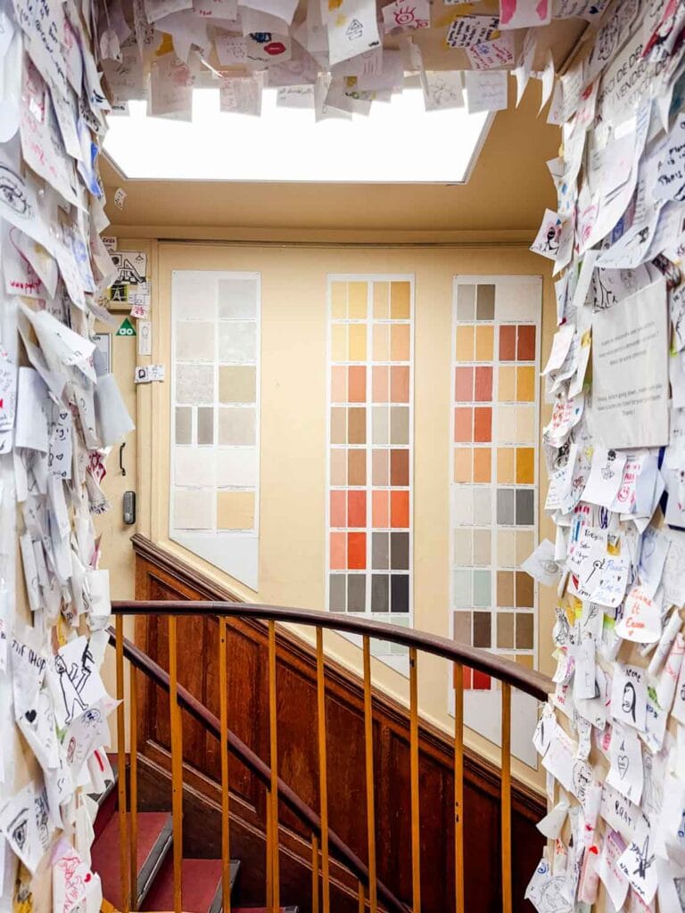 Up the stairs leading to the wall of a thousand strangers, the wall is filled with color pallets and color samples.