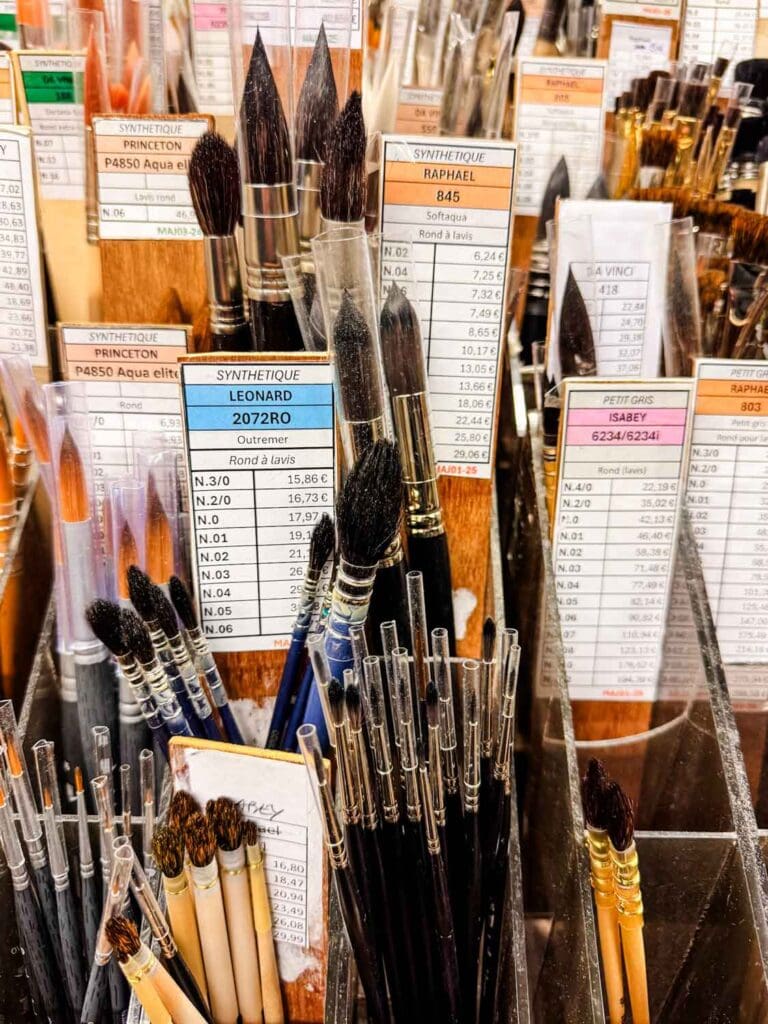 Various sizes and shapes of paint brushers are stacked in these bins inside the Sennelier art store in Paris.