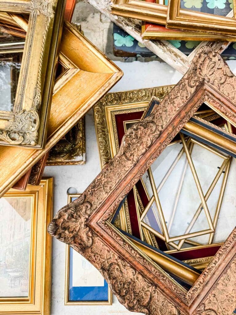 Vintage pictures in all patterns, shapes, and sizes are piled onto this table at the Portes des Vanves Flea Market in Paris.