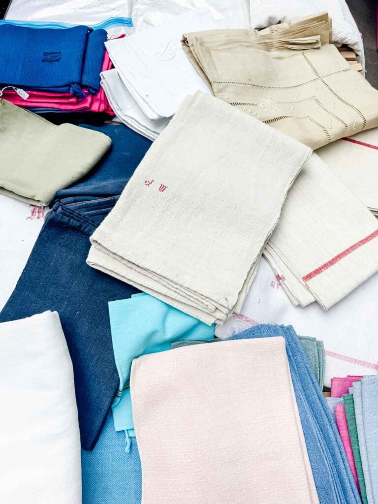 Monogramed French tea towels, displayed on this table, can be found at most flea markets throughout all of France.