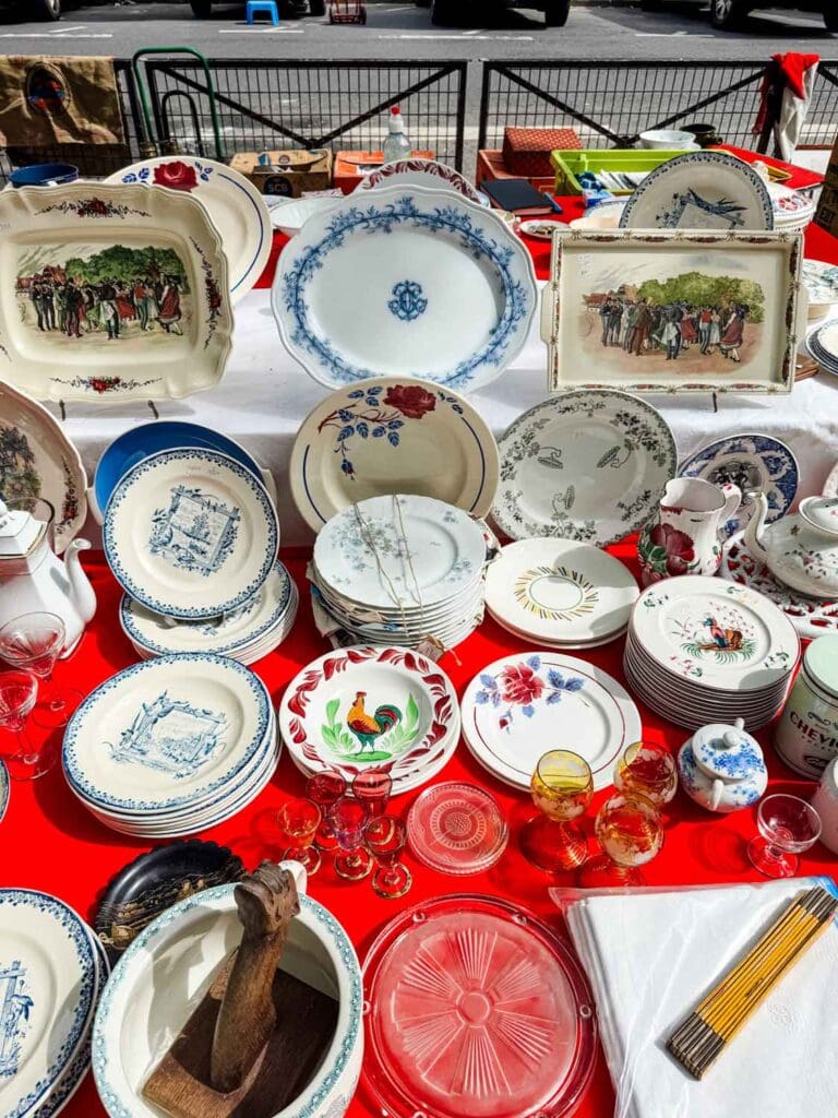 All kinds of different vintage plates on a red tablecloth at the Vanves flea market.