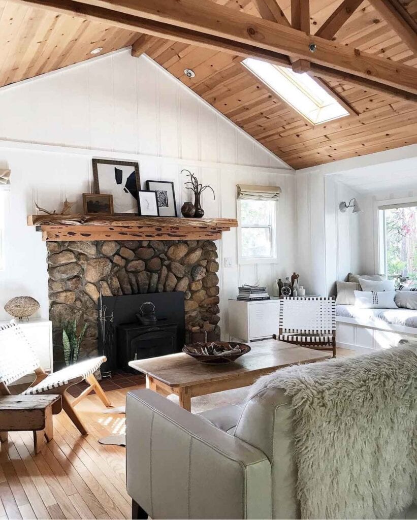 Cabin with stone firpleace, white walls.
