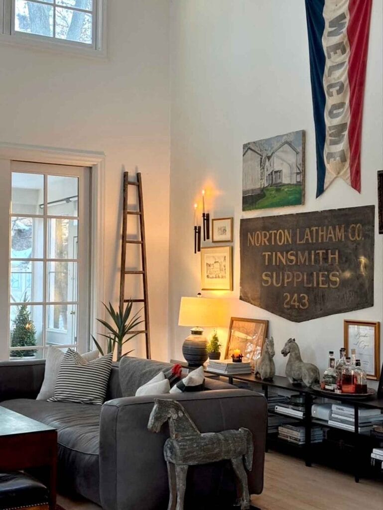 Eclectic gallery wall, wood horse statue, vintage apple picking ladder. 