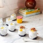 Jars of chia seed pudding is topped with lemon curd and granola.