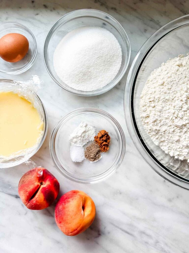 All the ingredients for making brown butter peach bars are measure and place in clear glass bowls.