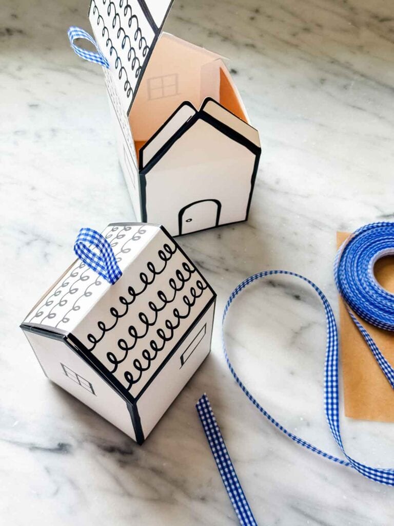 Small house-shaped boxes with blue gingham ribbon are used as containers to make a pretty package of peach shortbread bars.