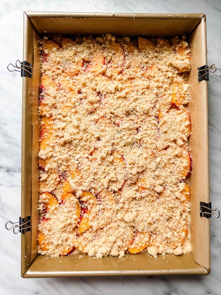 Some of the crumbly shortbread dough is sprinkled on top of the peaches along with some turbinado sugar.