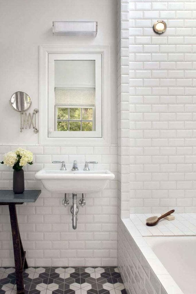 White bathroom, wall mounted sink. Window, black and white floor.