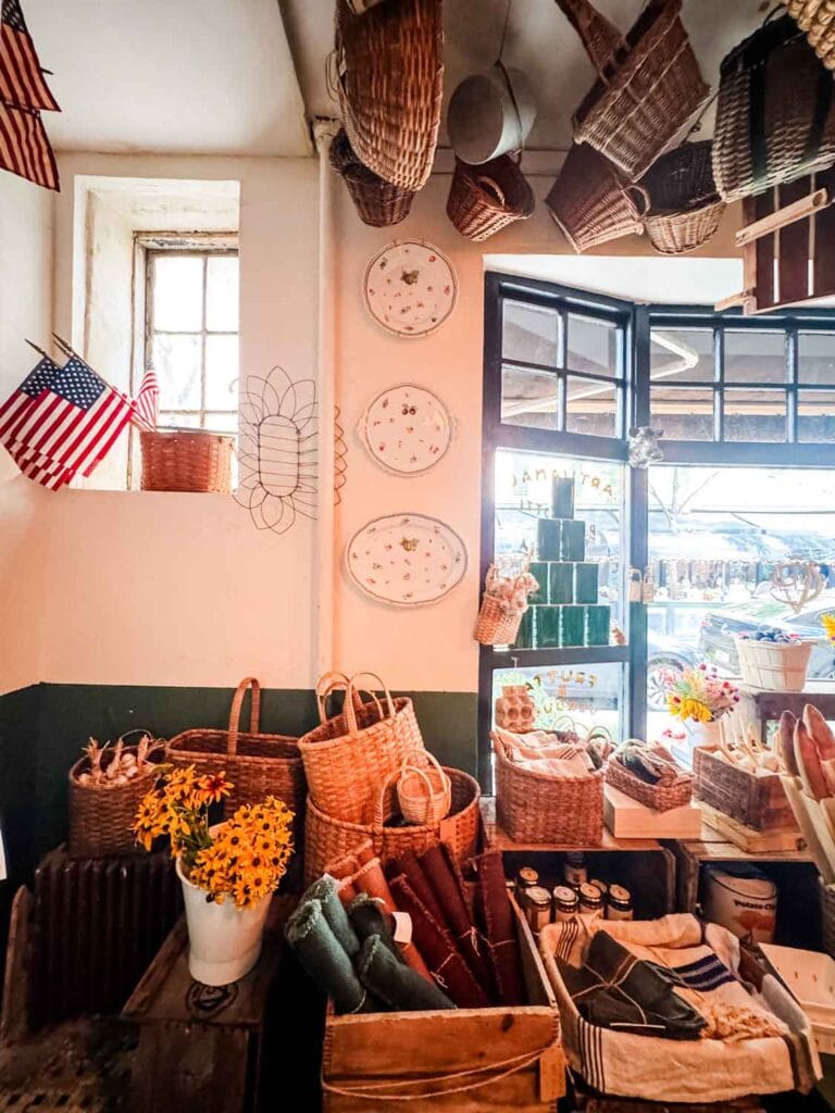 Hanging baskets, flowers in buckets, and vintage wood crates on display in Officina 1397 in the West Village.