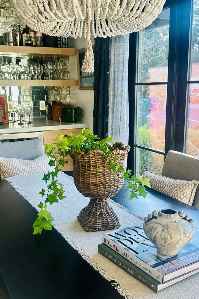 Rattan planter on dining table with a fern on a table.
