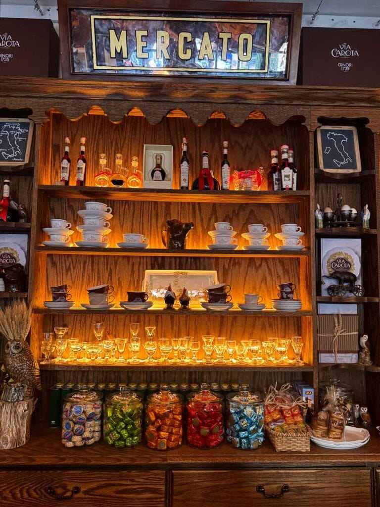 Balsamic vinegars, coffee cups and saucers and wine and champagne glasses line the shelves of a big hutch inside Officina 1397.