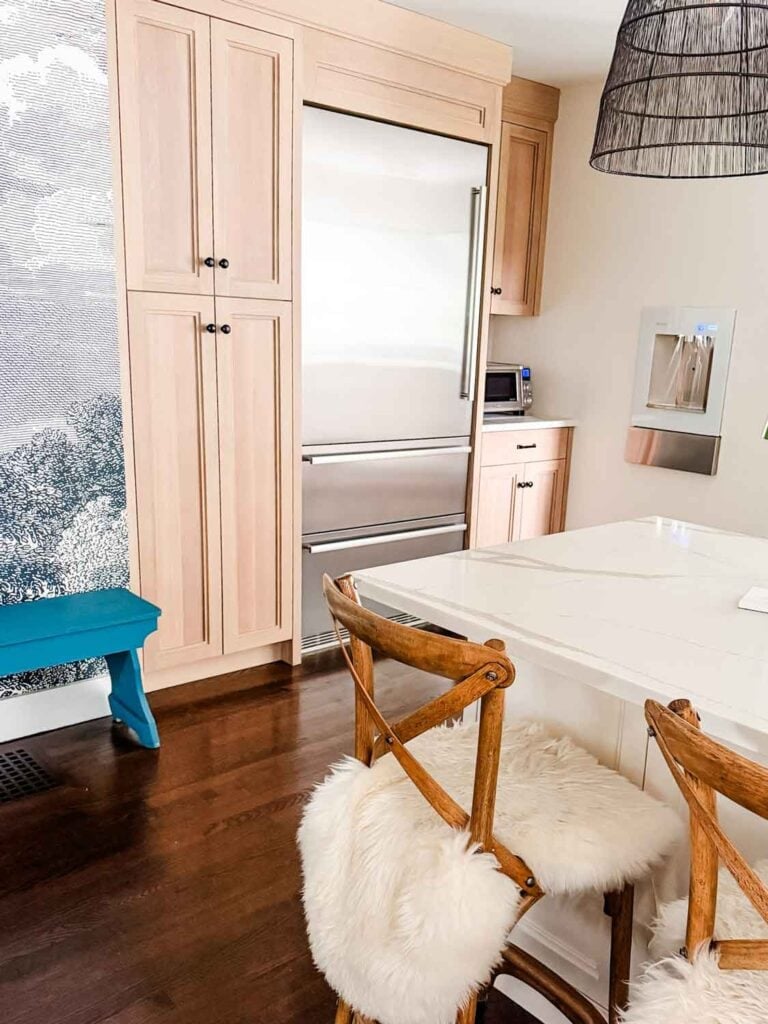 Built-in refrigerator and Elkay water station on wall. 