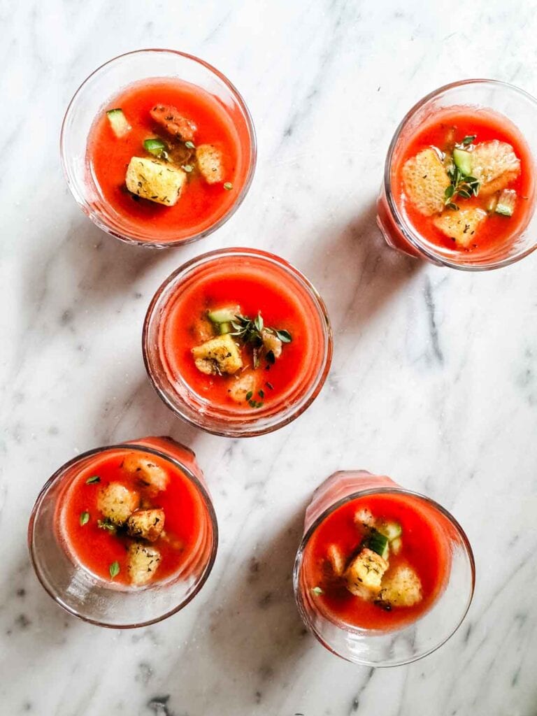 Small glasses of gazpacho soup with brioche croutons.