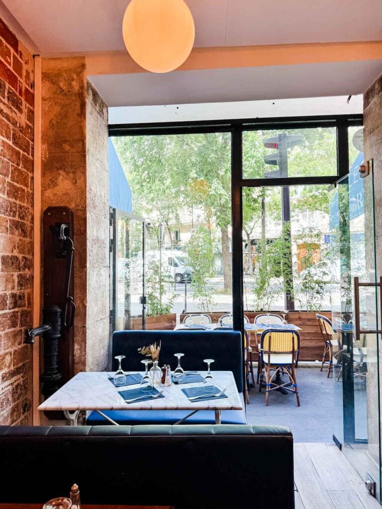 The seating inside Les Rupins in Paris is warm and cozy with the exposed red brick.