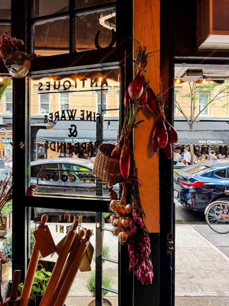 Large rolling pins are in a basket near the door at Officina 1397 and you can see the restaurant Via Carota just across the street.