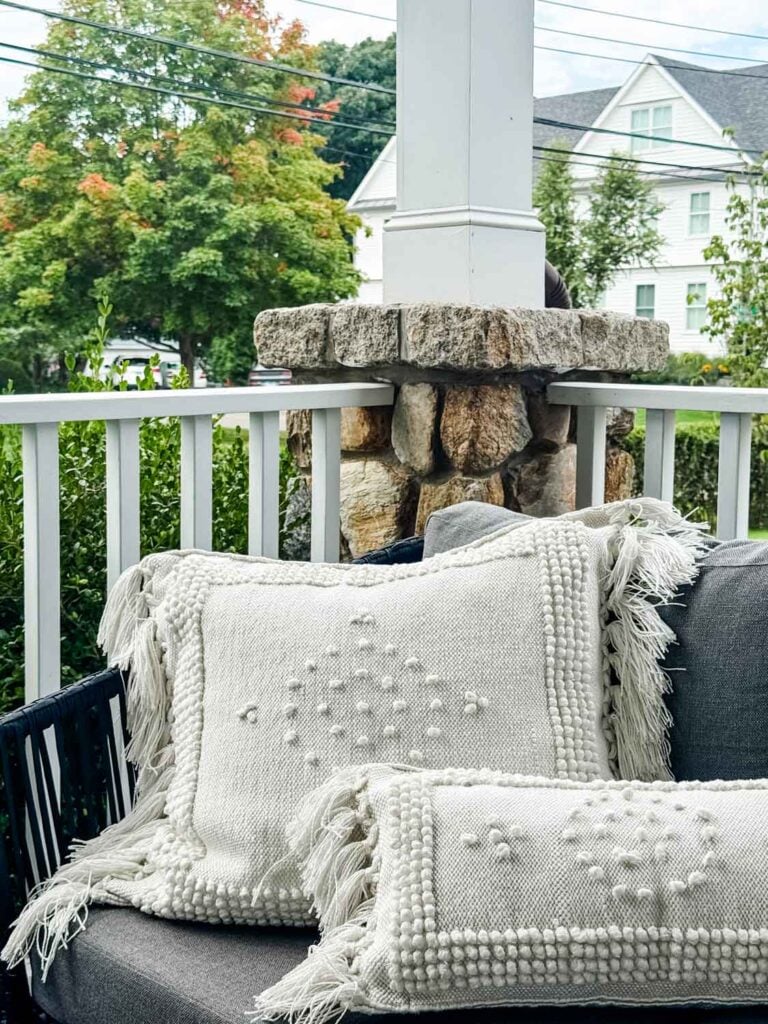Outdoor white pillows on sofa on porch.