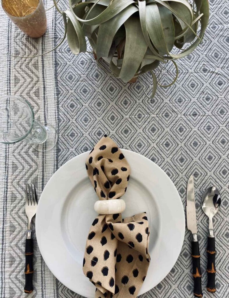 A mix of patterns, napkin on plate with tortoise flatware.