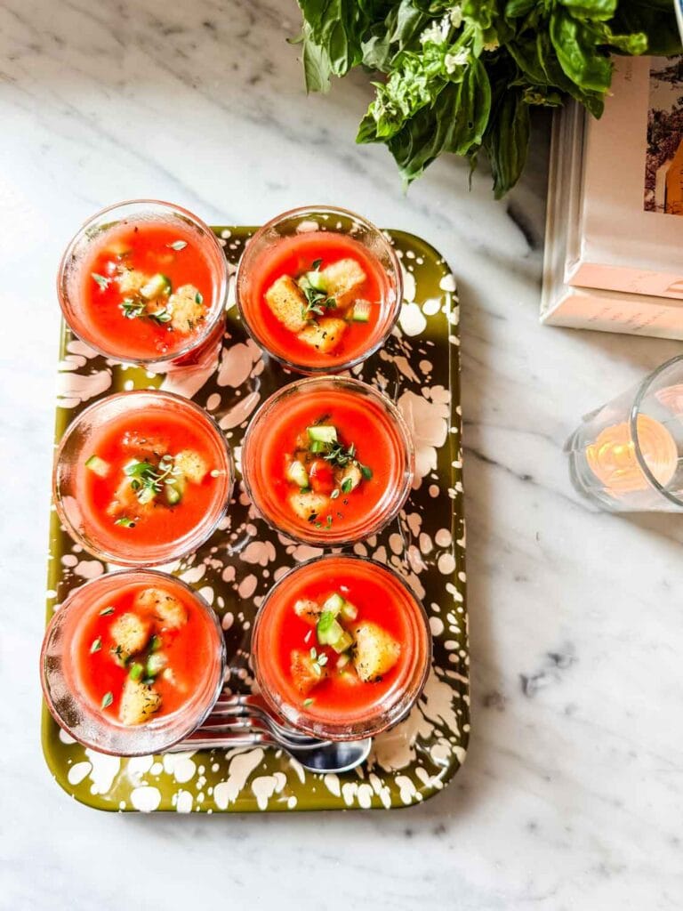 Small Duralex chilled glasses on green marbled tray with gazpacho.