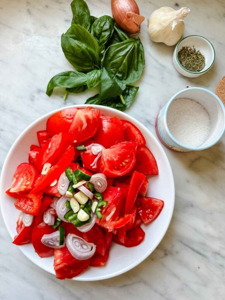 Bowl of chopped tomatoes, fresh basil, shallot, salt, garlic.