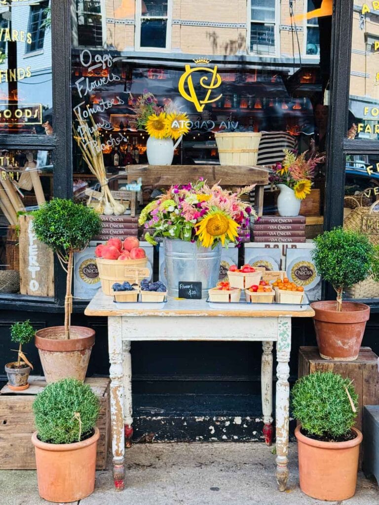 Fresh flowers and produce are on a vintage table in front of Officina in the West Village, New York City.