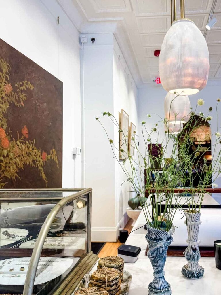 Pendant lighting, vases with wild flowers, coasters stacked.