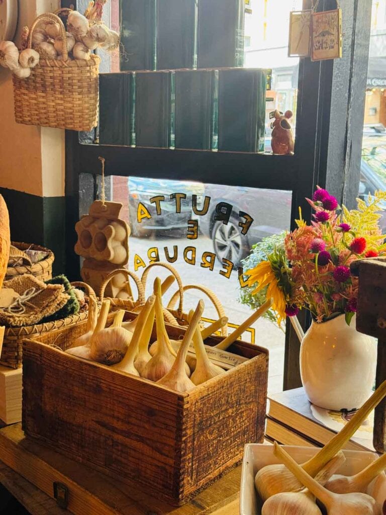 An old vintage crate is full of garlic cloves in the window at Officina 1397.