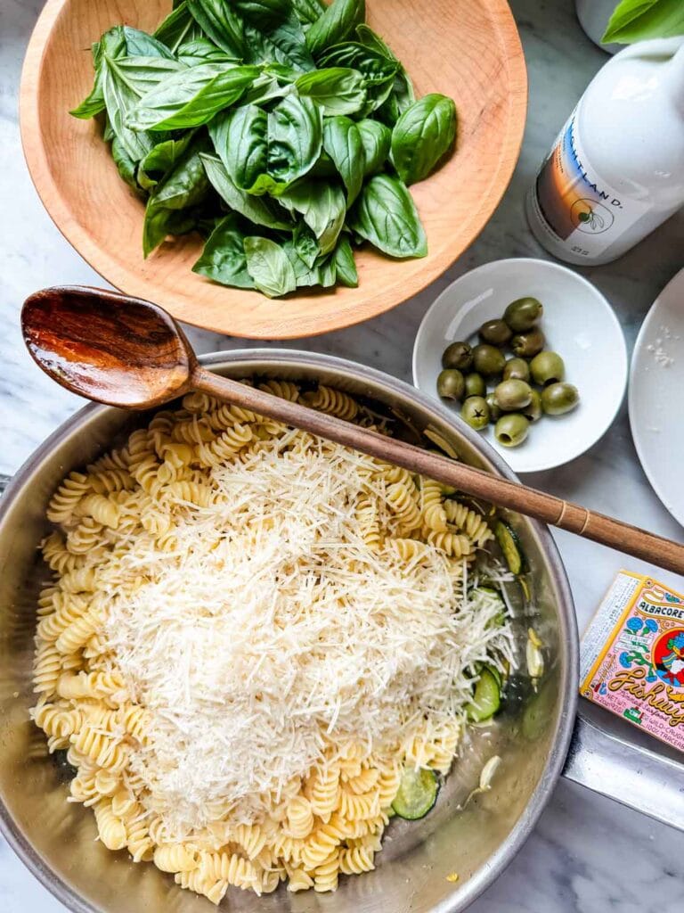 Adding the Parmesan cheese to the pasta.