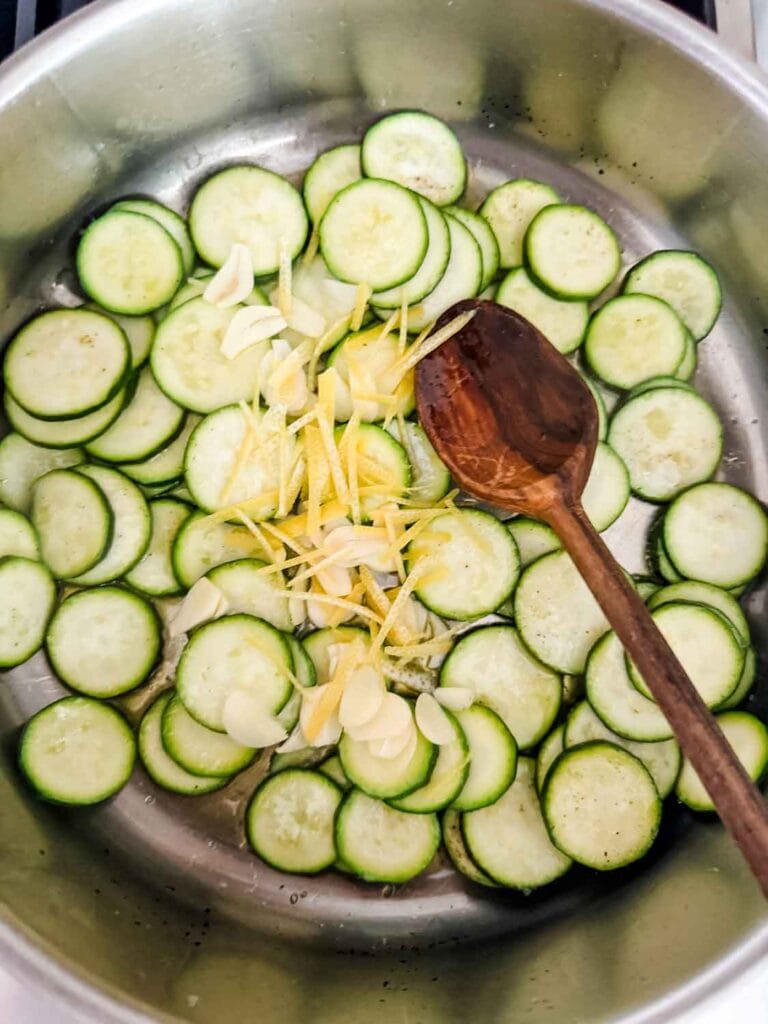 Sauteing the zucchini , garlic and lemon in pan with olive oil.