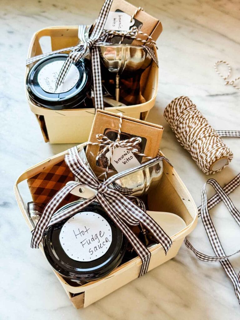 Wooden berry crates with vinatege stainless coupes, glass jars of hot fudge, small box of brownie bites, brown gingham ribbon, twine.